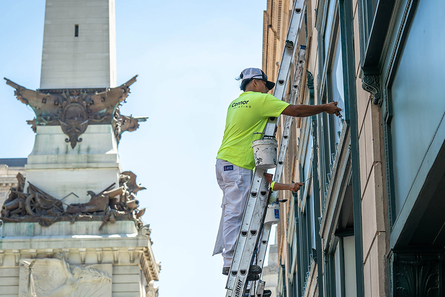 Connor Painting Employee with Ladder and Paint Bucket